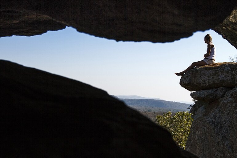 An unusual perspective of an amazing view admired by a good friend sitting on a ​ distant rock.